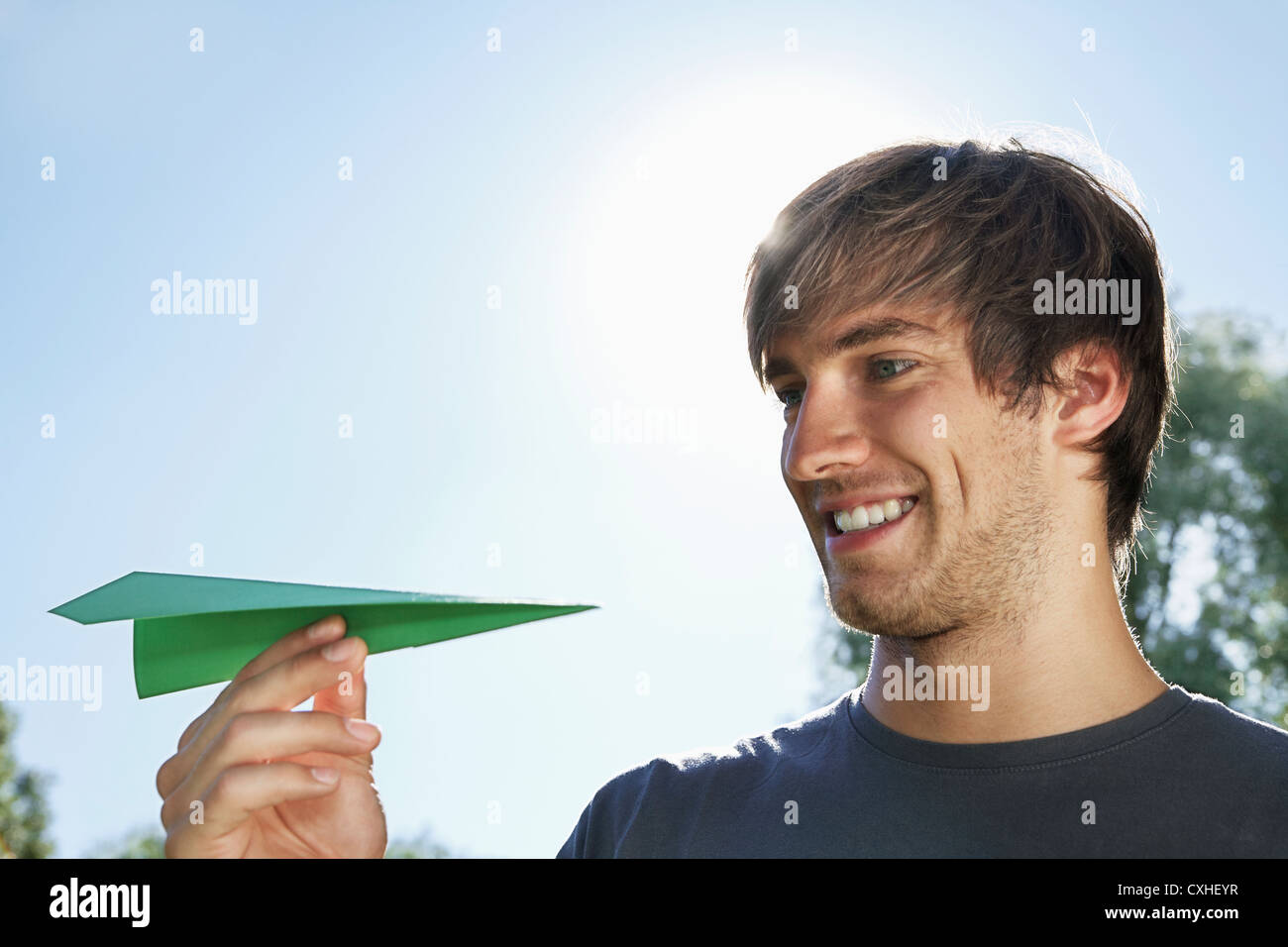 Germany, Cologne, Young man holding paper plane Stock Photo