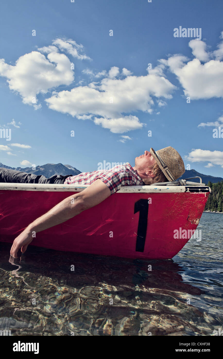 Germany, Bavaria, Mid adult man sleeping in rowing boat Stock Photo