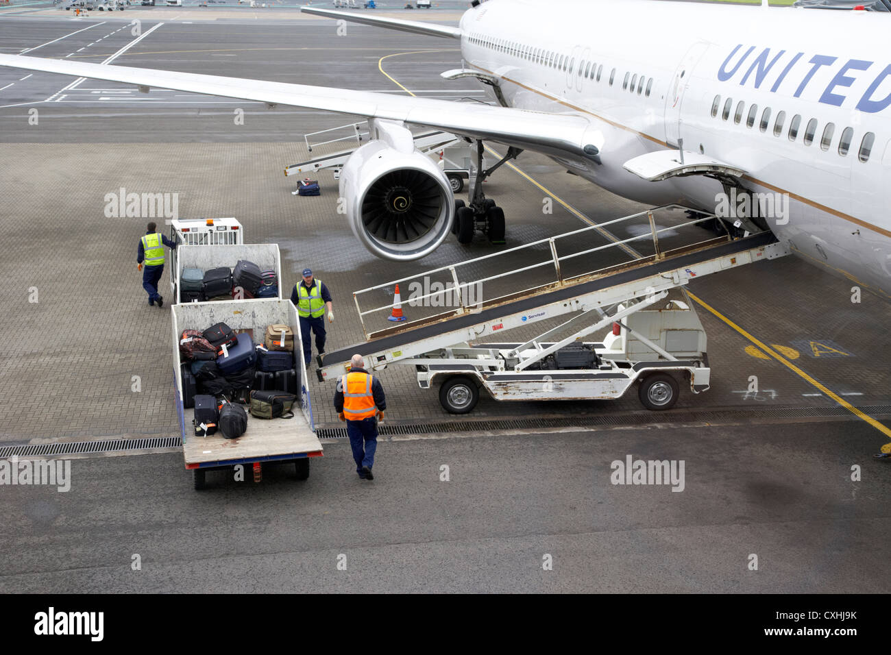 baggage handlers loading United Airlines Boeing 757 at Belfast International Airport Stock Photo