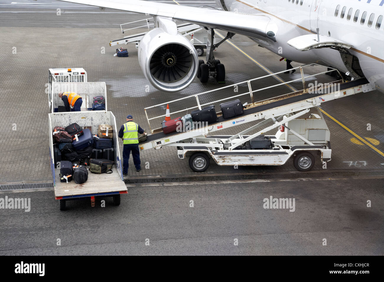 baggage handlers loading United Airlines Boeing 757 at Belfast International Airport Stock Photo