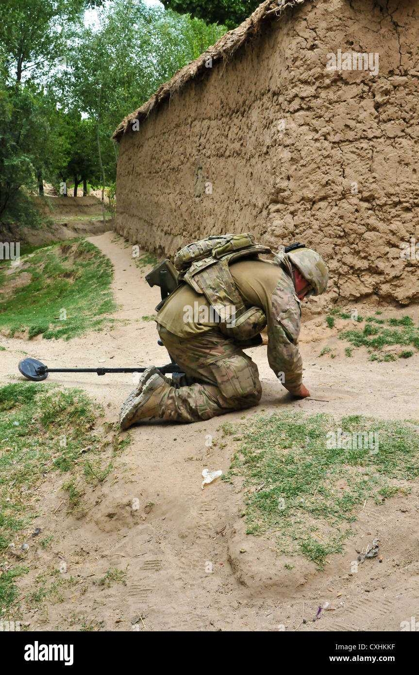 TARIN KOT, Afghanistan - An Australian Army soldier with the 2nd Combat Engineer Regiment, Royal Australian Engineers, checks the ground for an IED during Operation Kalak Hode 5, a major clearance operation in the Khas Uruzgan district of Afghanistan, Sept. 7, 2012. Stock Photo