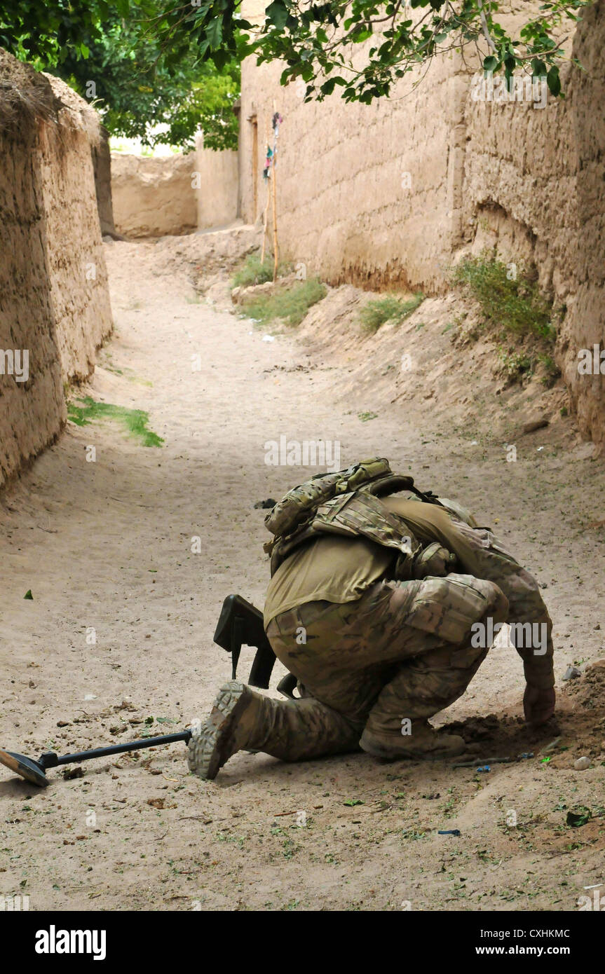 TARIN KOT, Afghanistan - An Australian Army soldier with the 2nd Combat Engineer Regiment, Royal Australian Engineers, checks the ground for an IED during Operation Kalak Hode 5, a major clearance operation in the Khas Uruzgan district of Afghanistan, Sept. 7, 2012. Stock Photo