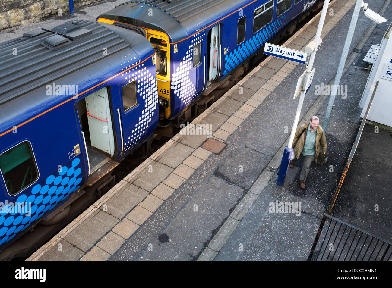 Middle aged man, possibly a commuter, leaving a train in Clarkston near Glasgow. Stock Photo