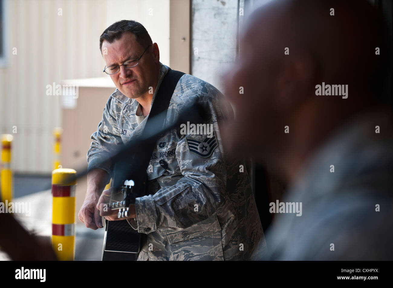 Staff Sgt. Gregory Lacy plays the guitar during a U.S. Air Forces Central Band 'Top Flight' performance at the Transit Center at Manas, Kyrgyzstan, Sept. 22, 2012. This performance, which was held in the 376th Expeditionary Logistics Readiness Squadron facility, was played in conjunction with a BBQ to improve morale. Lacy is deployed from Joint Base San Antonio, Texas and a native of Houston. Stock Photo