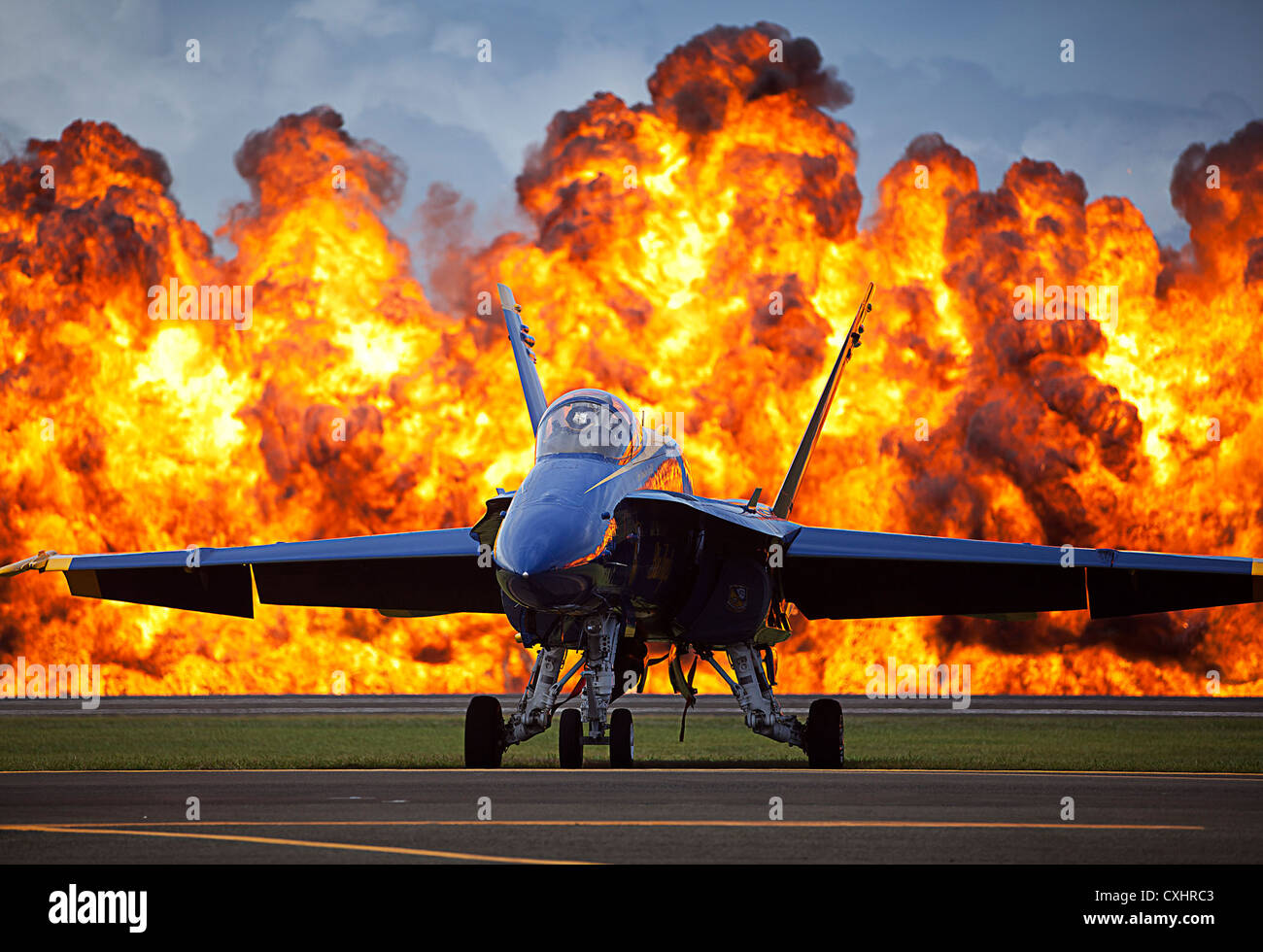 A wall of fire erupts behind a Blue Angels F/A-18 aircraft as part of a Marine Air-Ground Task Force demonstration during the 2012 Kaneohe Bay Air Show on Marine Corps Air Station, Kaneohe Bay, Hawaii, Sept. 28, 2012. Thousands of visitors flocked to the air show, Sept. 29 and 30, to witness stunning performances by the Blue Angels and a variety of other military and civilian aircraft. Service members enjoyed a military appreciation day during the eventâ€™s Sept. 28 rehearsal. The free event was open to the public and celebrated the centennial of Marine Corps aviation. Stock Photo