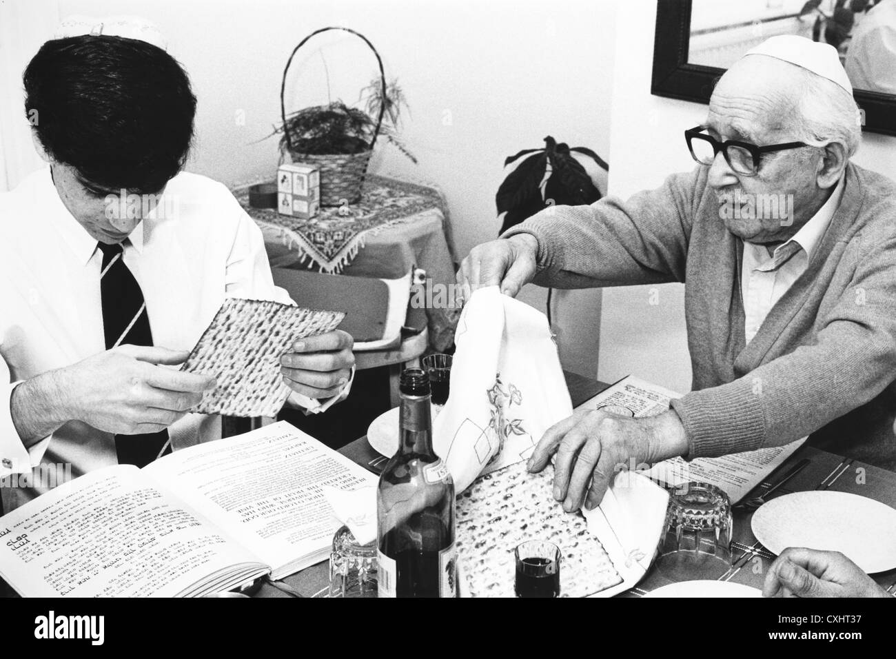 Breaking matzo unleavened bread part of the feast of the Passover service in a Jewish home 1980s Stock Photo