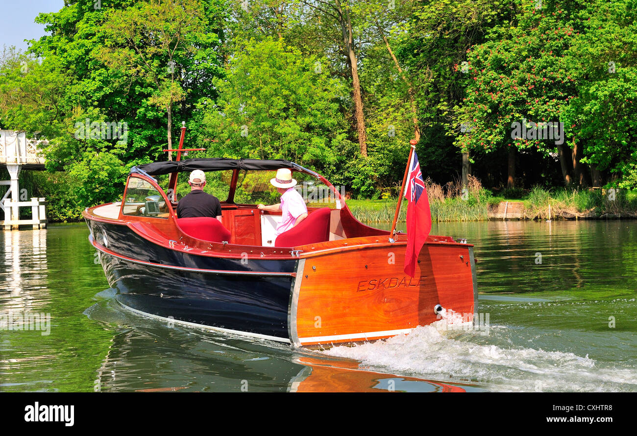 Two men cruising on a gentleman's motor yacht, on the  upper reaches of the River Thames, Pangbourne, Berkshire, England, UK Stock Photo