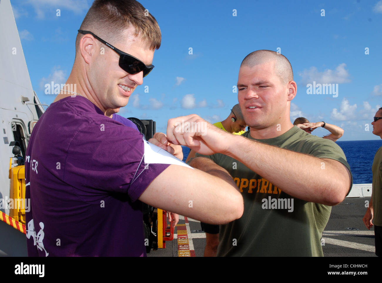 Capt. Brian Kennedy helps Capt. Zachary Jones attach his race number during the Landaker 5k held by the “Purple Foxes” of Marine Medium Helicopter Squadron (HMM) 364 (REIN) aboard amphibious transport dock ship USS Green Bay (LPD 20). Green Bay is part of the Peleliu Amphibious Ready Group currently underway on a Western Pacific deployment with amphibious assault ship USS Peleliu (LHA 5) and amphibious dock landing ship USS Rushmore (LSD 47) Stock Photo