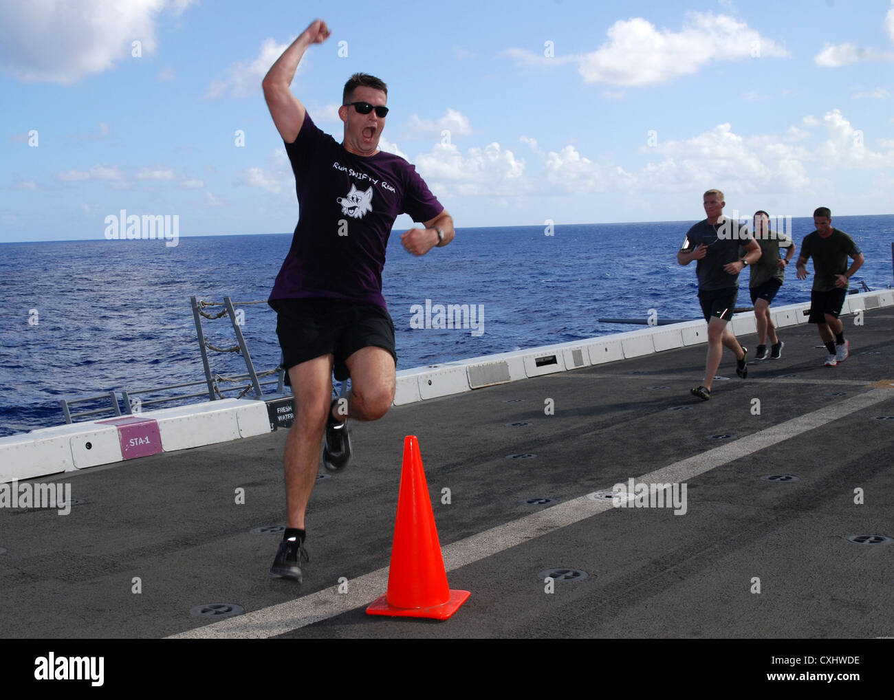 Capt. Zachary Jones expresses his excitement as he finishes the Landaker 5k held by the â€œPurple Foxesâ€ of Marine Medium Helicopter Squadron (HMM) 364 (REIN) aboard amphibious transport dock ship USS Green Bay (LPD 20). Green Bay is part of the Peleliu Amphibious Ready Group currently underway on a Western Pacific deployment with amphibious assault ship USS Peleliu (LHA 5) and amphibious dock landing ship USS Rushmore (LSD 47). Stock Photo