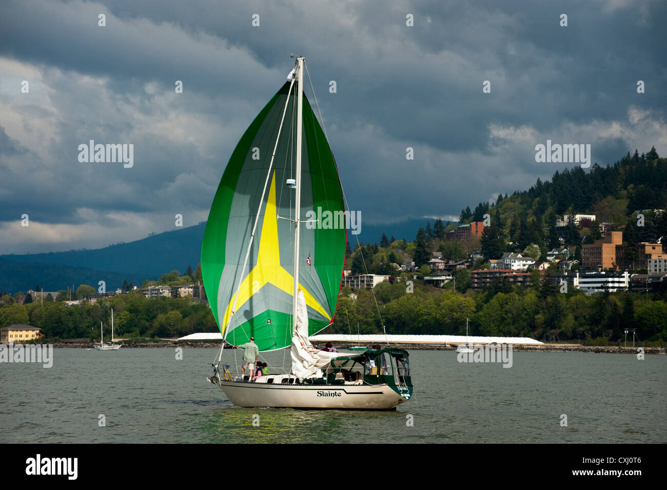 A sailboat on Bellingham Bay raises a colorful spinnaker sail during a ...