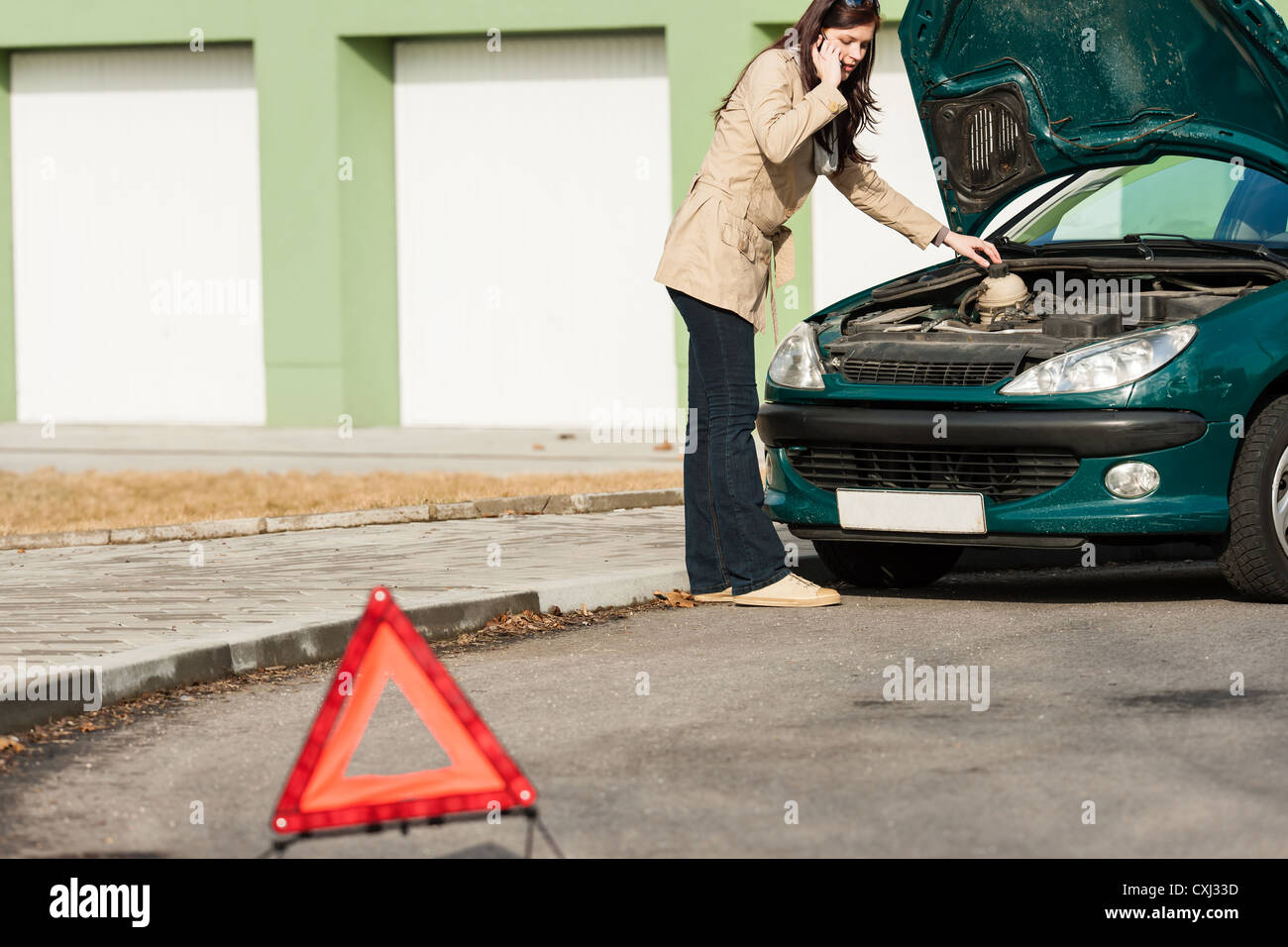 Car breakdown couple calling for road assistance look engine Stock