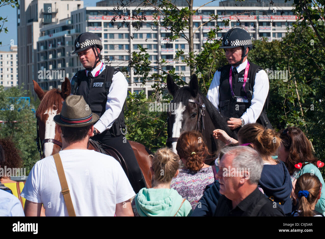 London 2012 Paralympics , Olympic Park Stratford , two mounted policemen police men male cops on horses help crowd visitors Stock Photo