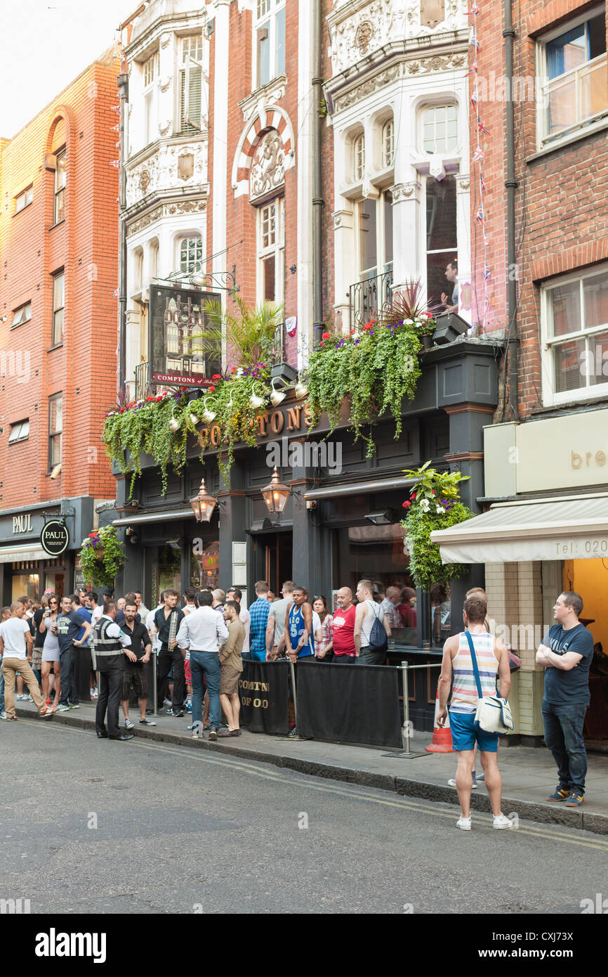 People standing outside the Comptons bar in Soho, London, UK Stock Photo