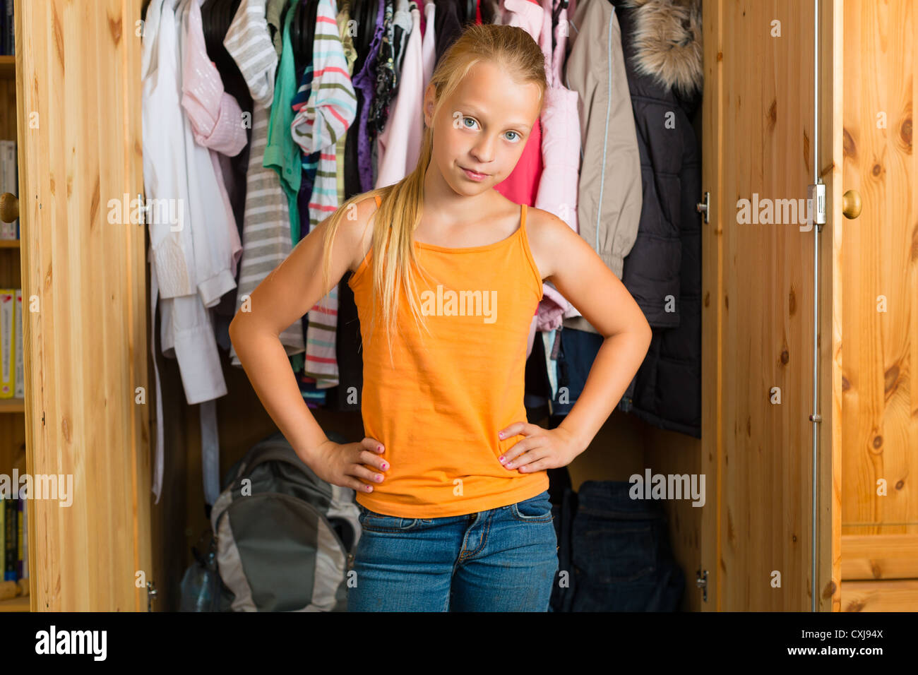 Family - child or teenager in front of her closet or wardrobe and looking for outfit Stock Photo