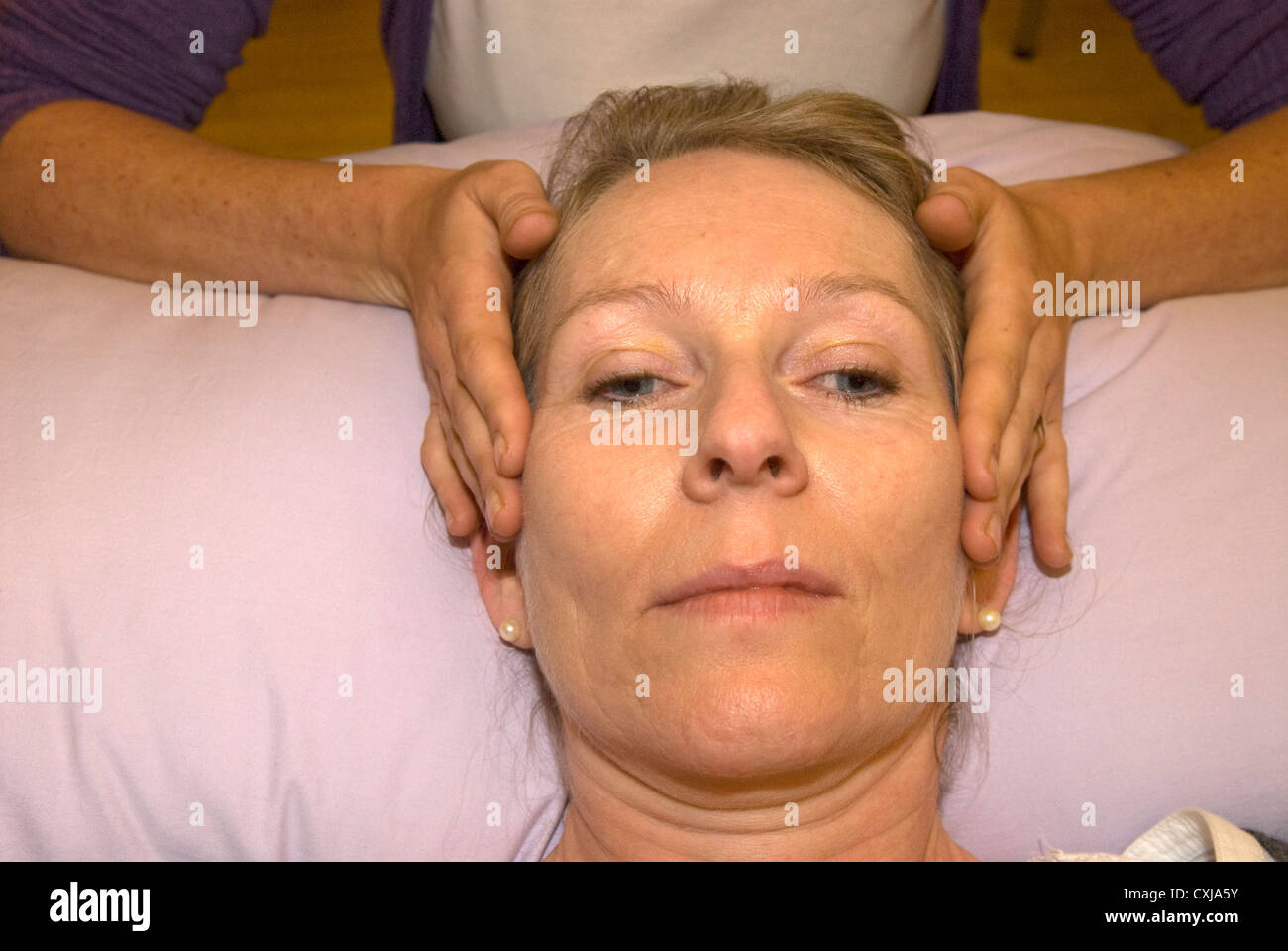 Practitioner giving Cranio-Sacral therapy to patient at a alternative therapies event, Alton, Hampshire, UK. Stock Photo