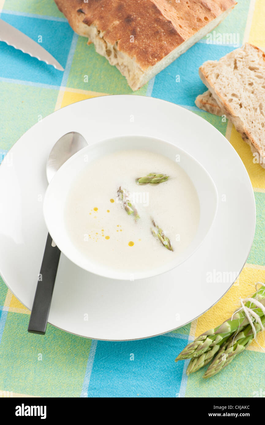 Mixed creamy asparagus soup garnished with green asparagus served with bread Stock Photo