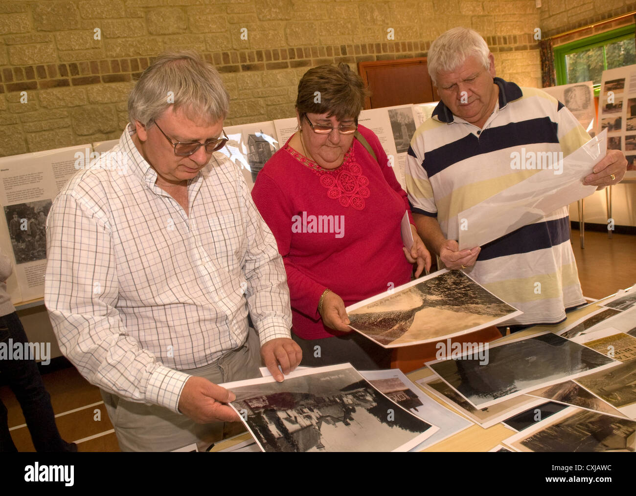 Visitors perusing old photographs of Buriton at a local history exhibition, Buriton Village Hall, near Petersfield, Hampshire Stock Photo