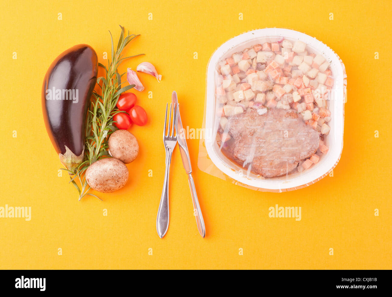 Contrasting food, choice between fresh healthy vegetables and microwave meal Stock Photo