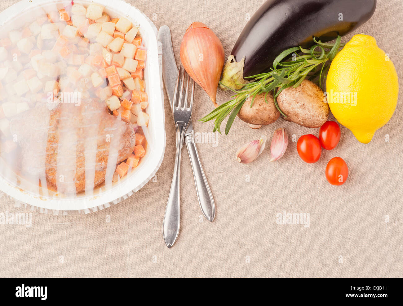 Contrasting food, choice between fresh healthy vegetables and microwave meal Stock Photo