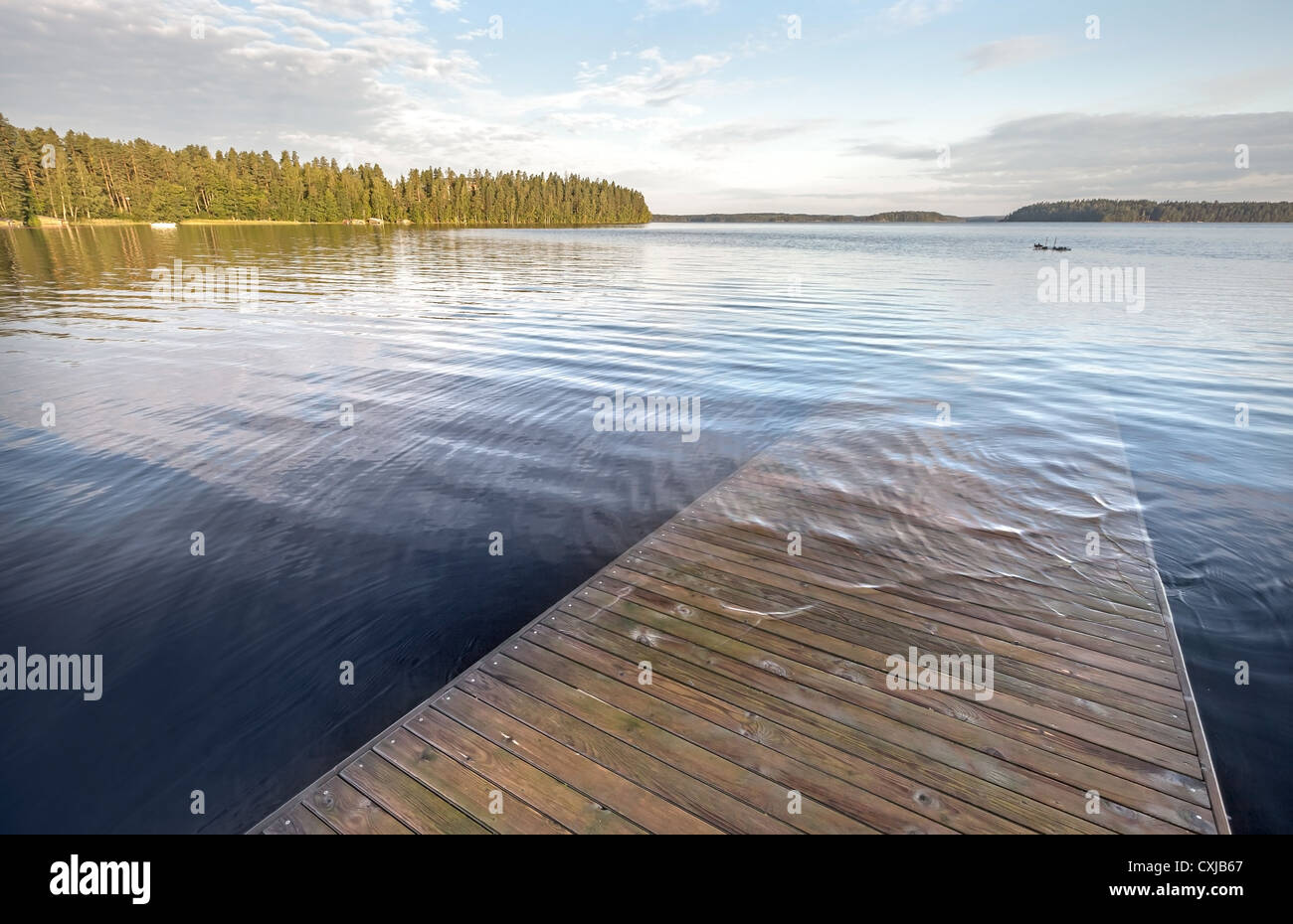 Old wooden pier goes under deep water on the lake Stock Photo