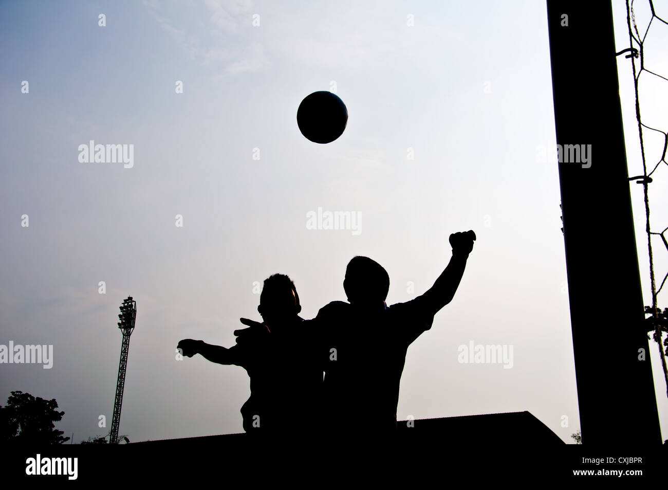 silhouette of football player heading for goal Stock Photo