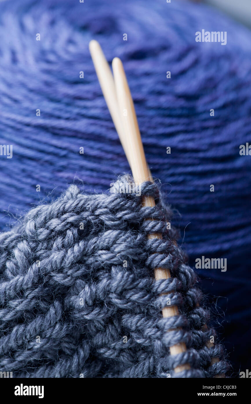 Incomplete knitting project with ball of blue wool, close up Stock Photo