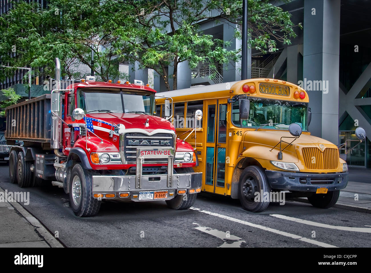 Red truck and yellow school bus in a street of downtown Manhattan - New york USA Stock Photo