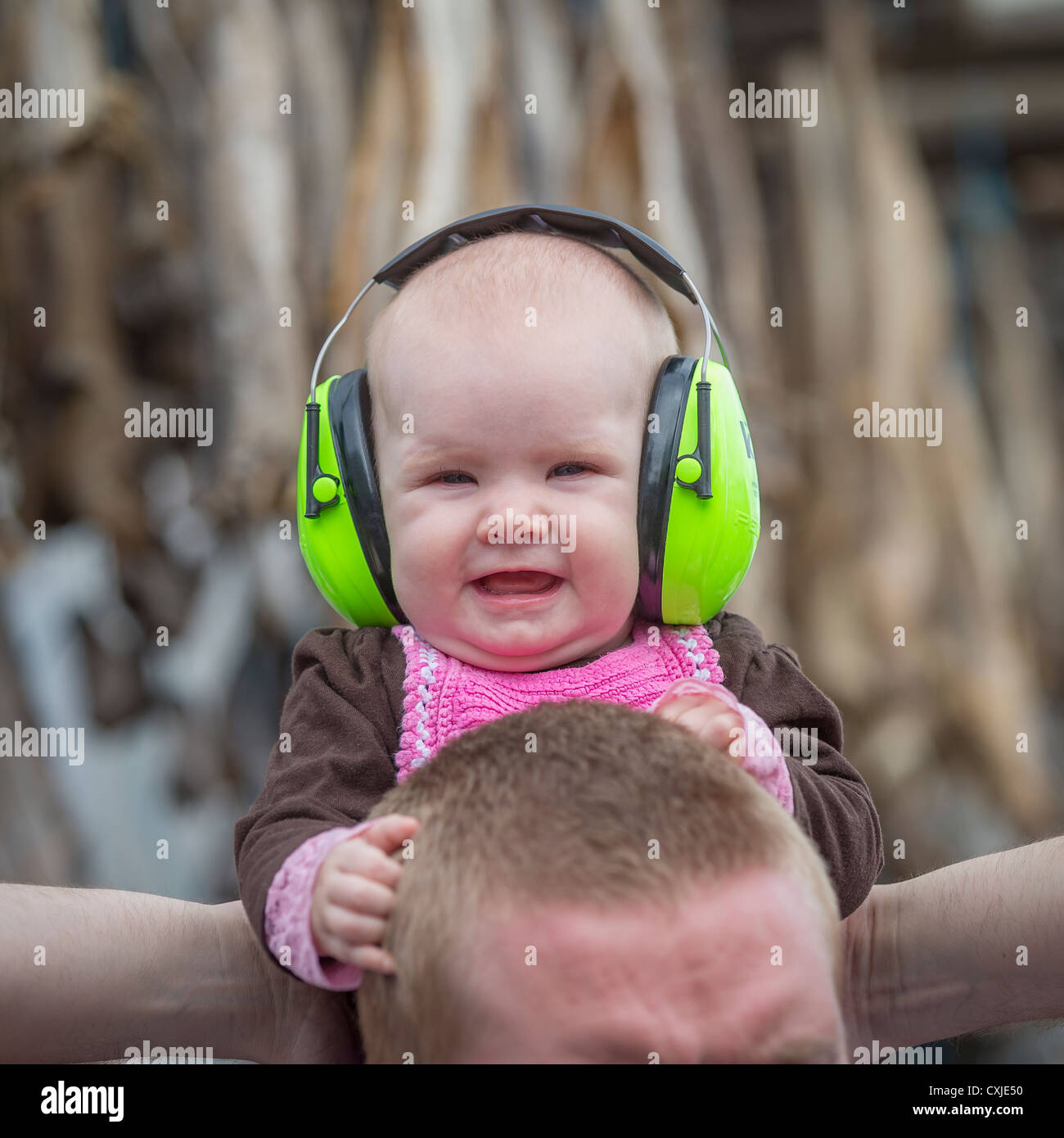 Baby wearing noise reduction ear muffs. Protective headphones on young baby at an outdoor festival, Dalvik, Iceland Stock Photo