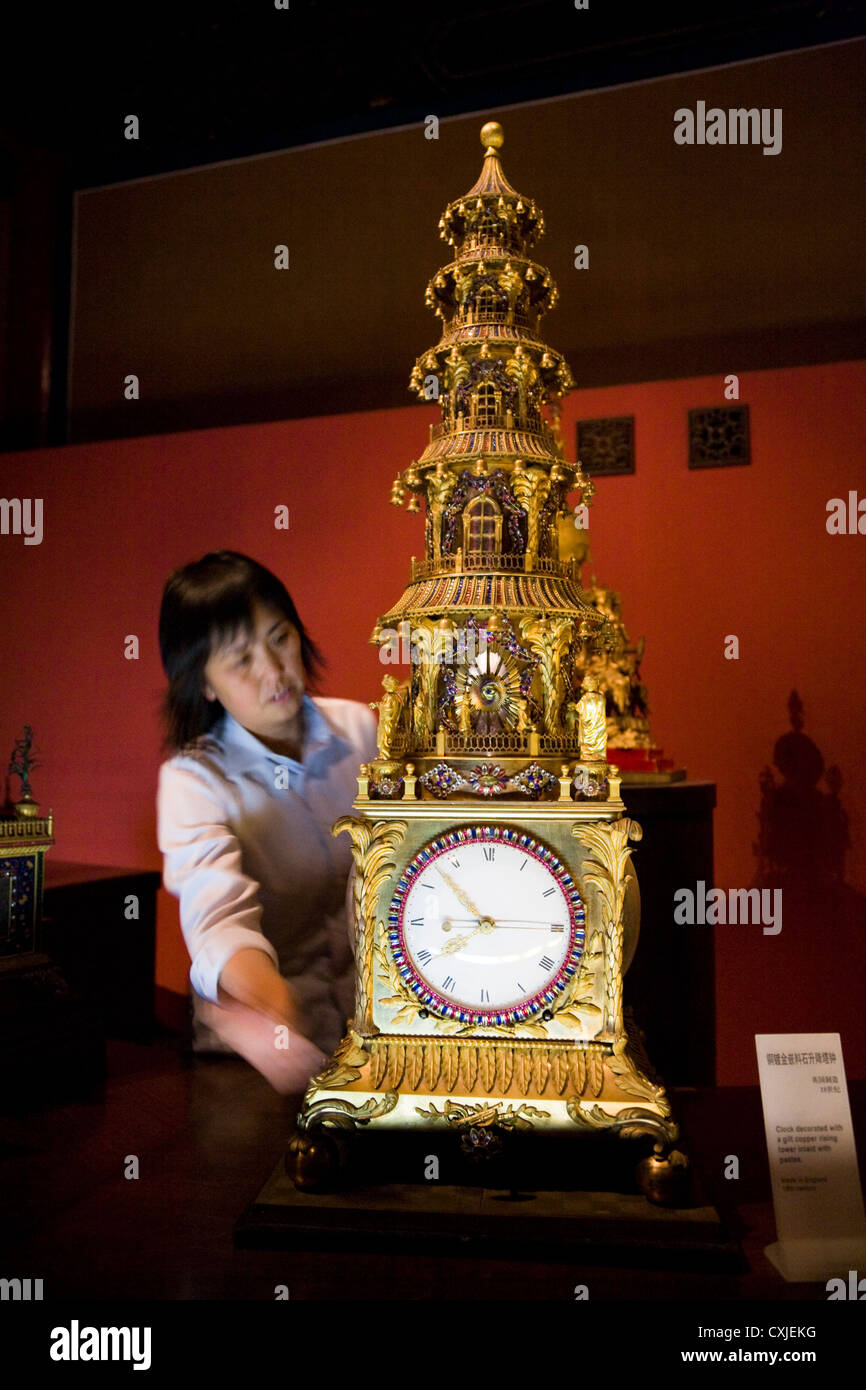 Curator operates a rare clock / clocks in the clock museum at Palace Museum, The Forbidden City. Beijing. China. Stock Photo
