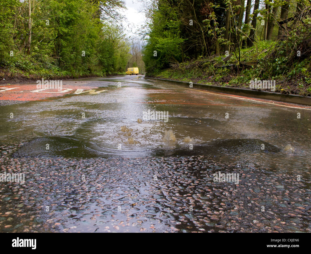 Flooding on a country road near Nutfield marsh causing problems for cars Stock Photo