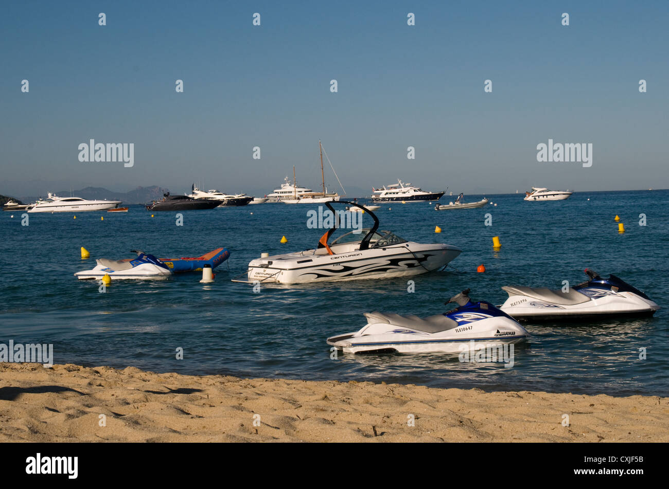 Wave riders,speed boats and luxury yachts moored off of Pampelonne beach near St Tropez in the south of France. Stock Photo