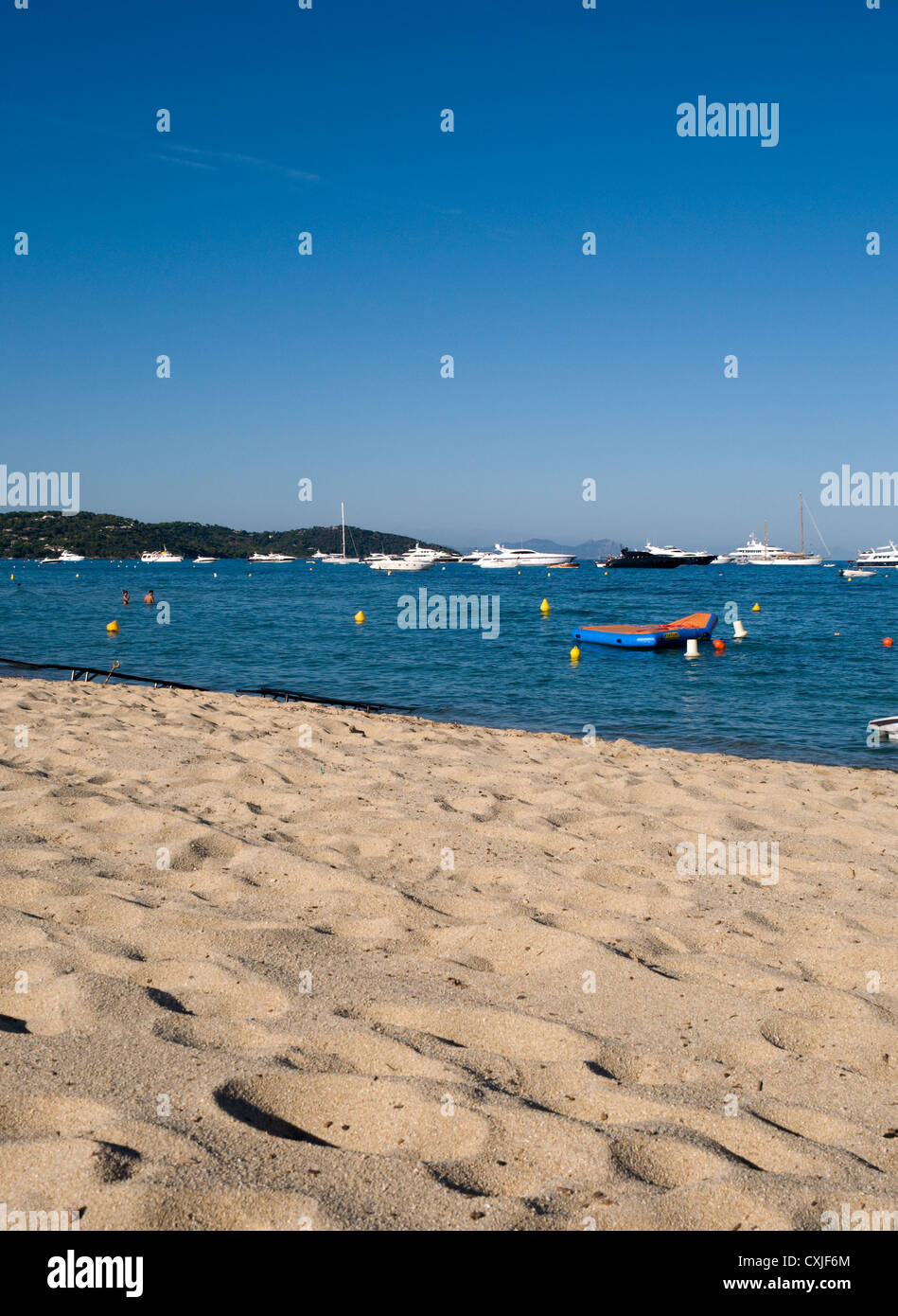 The golden sand of Pampelonne beach with luxury yachts and speed boats moored in the sea. The beach is close to St Tropez Stock Photo