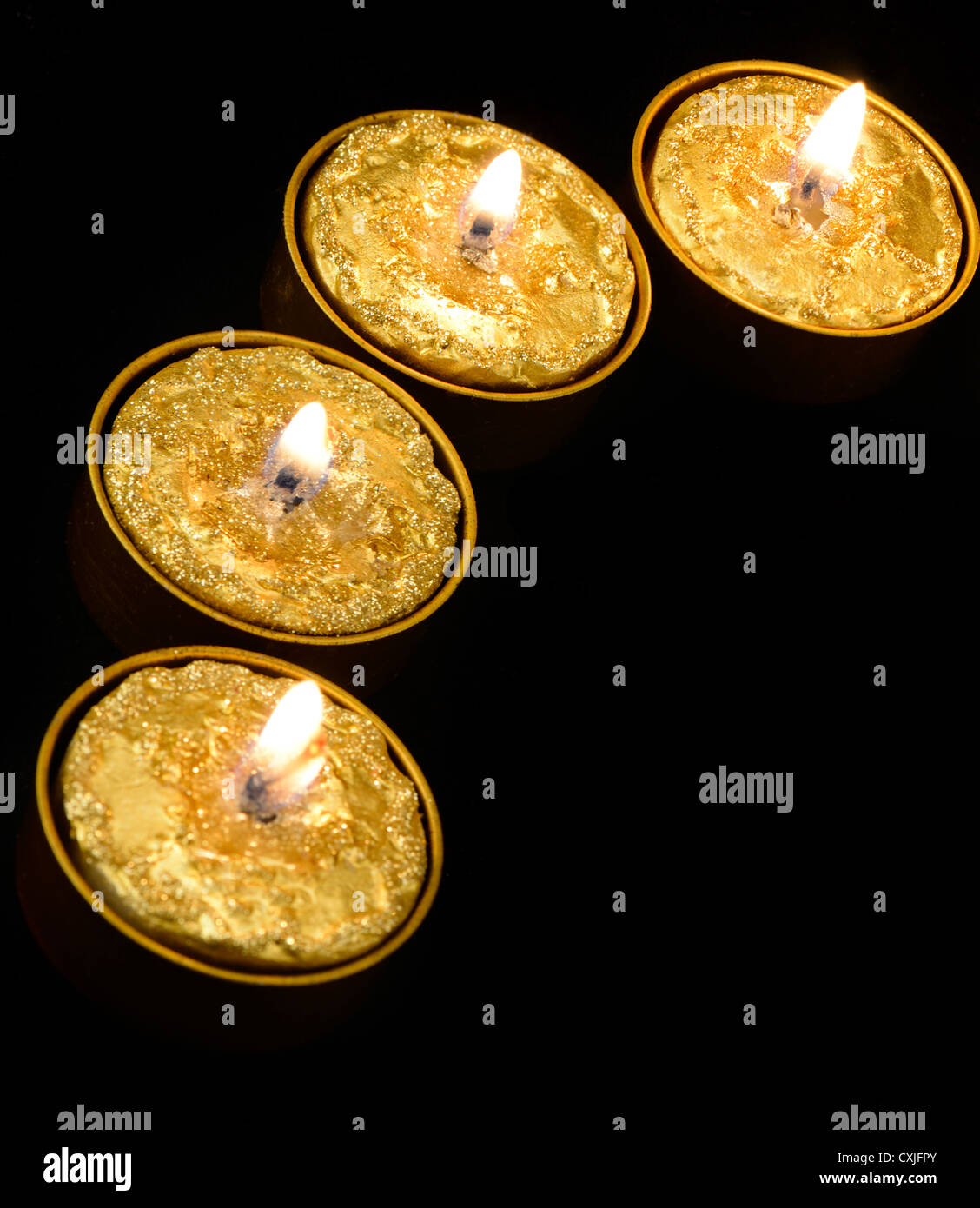 Golden burning candles on a black background Stock Photo - Alamy