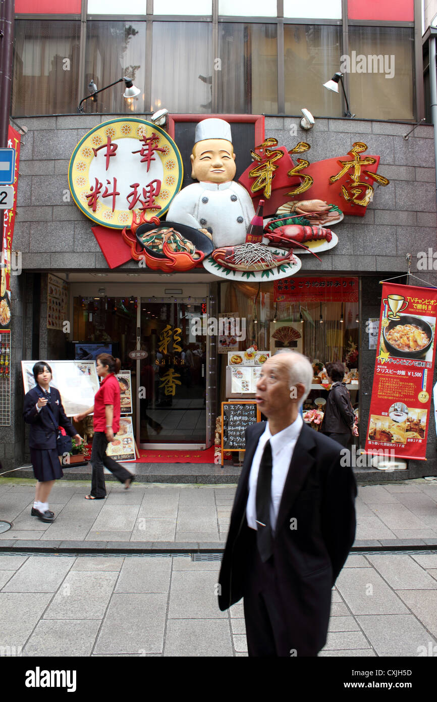 Elderly Japanese man standing outside restaurant in Chinatown, Yokohama looking slightly bewildered Stock Photo