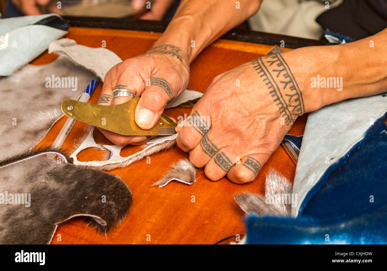 Inuit woman demonstrates seal skin cutting and sewing techniques Stock