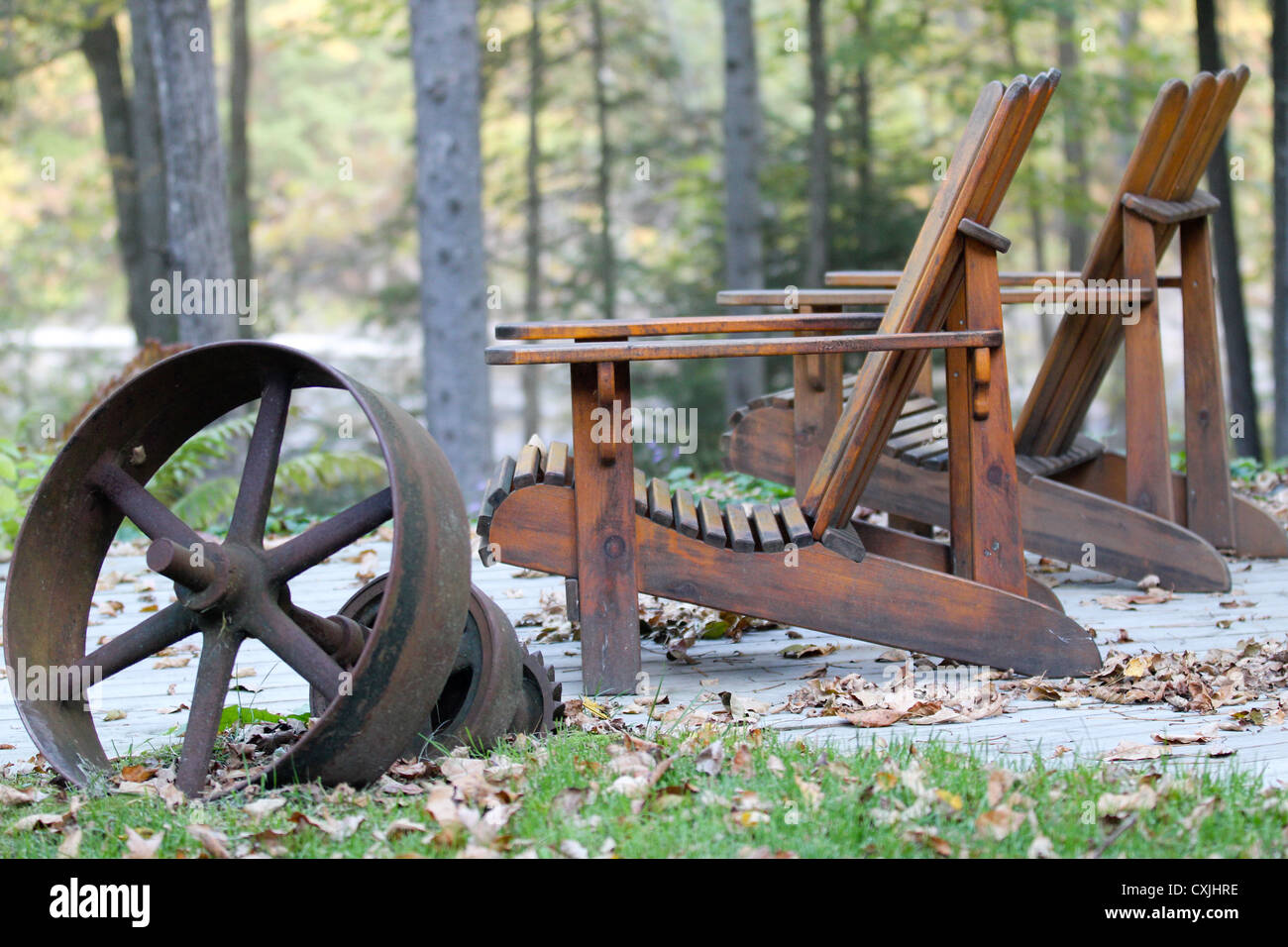 Two Adirondack chairs and rustic machinery Stock Photo - Alamy