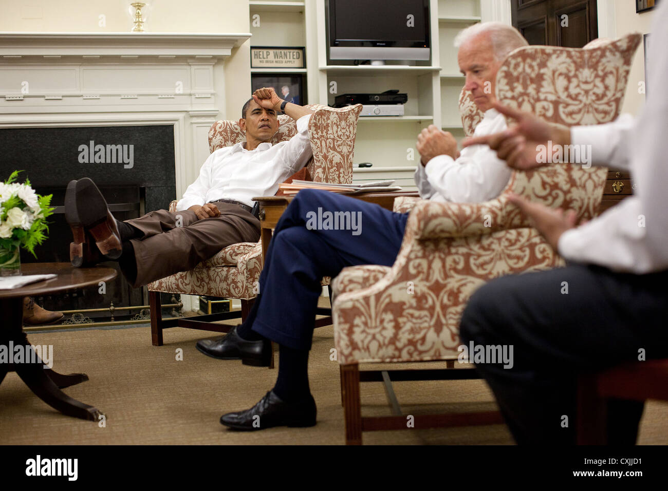 US President Barack Obama and Vice President Joe Biden are briefed by Rob Nabors, Assistant to the President for Legislative Affairs July 30, 2011 during a meeting in Chief of Staff Bill Daley's West Wing office at the White House to discuss ongoing efforts to find a balanced approach to the debt limit and deficit reduction. Stock Photo