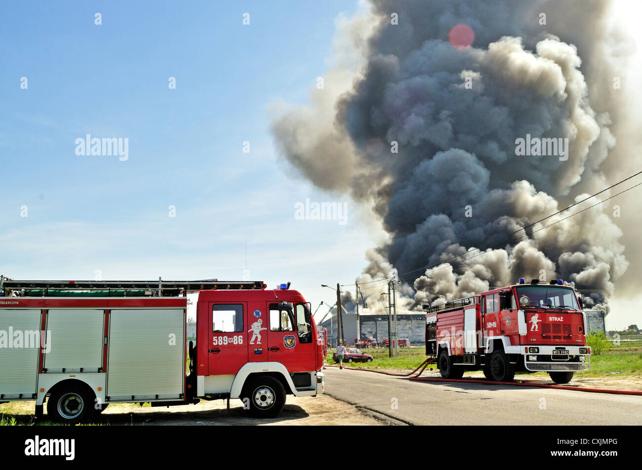 Firefighters extinguish a raging fire in a storehouse. Stock Photo
