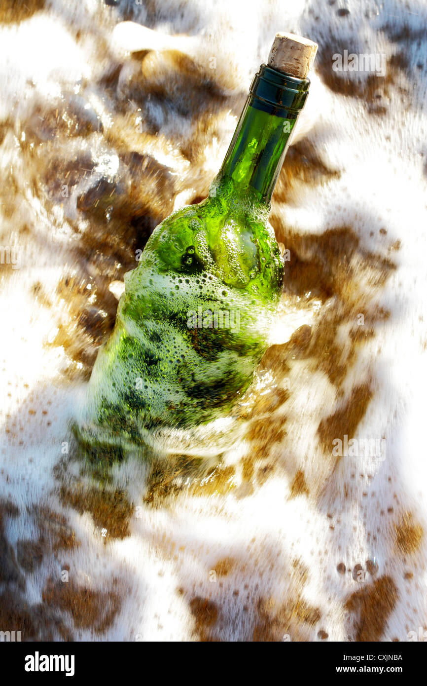 Message in a glass bottle in a solitary beach near the sea Stock Photo