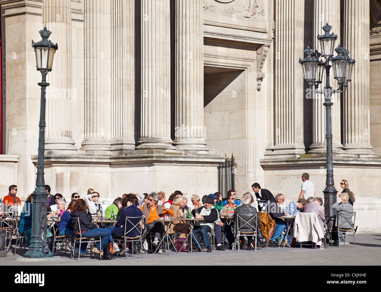 Visitors to the Musée du Louvre, Paris, France, eating, drinking and chatting in the museum's courtyard cafe. Stock Photo