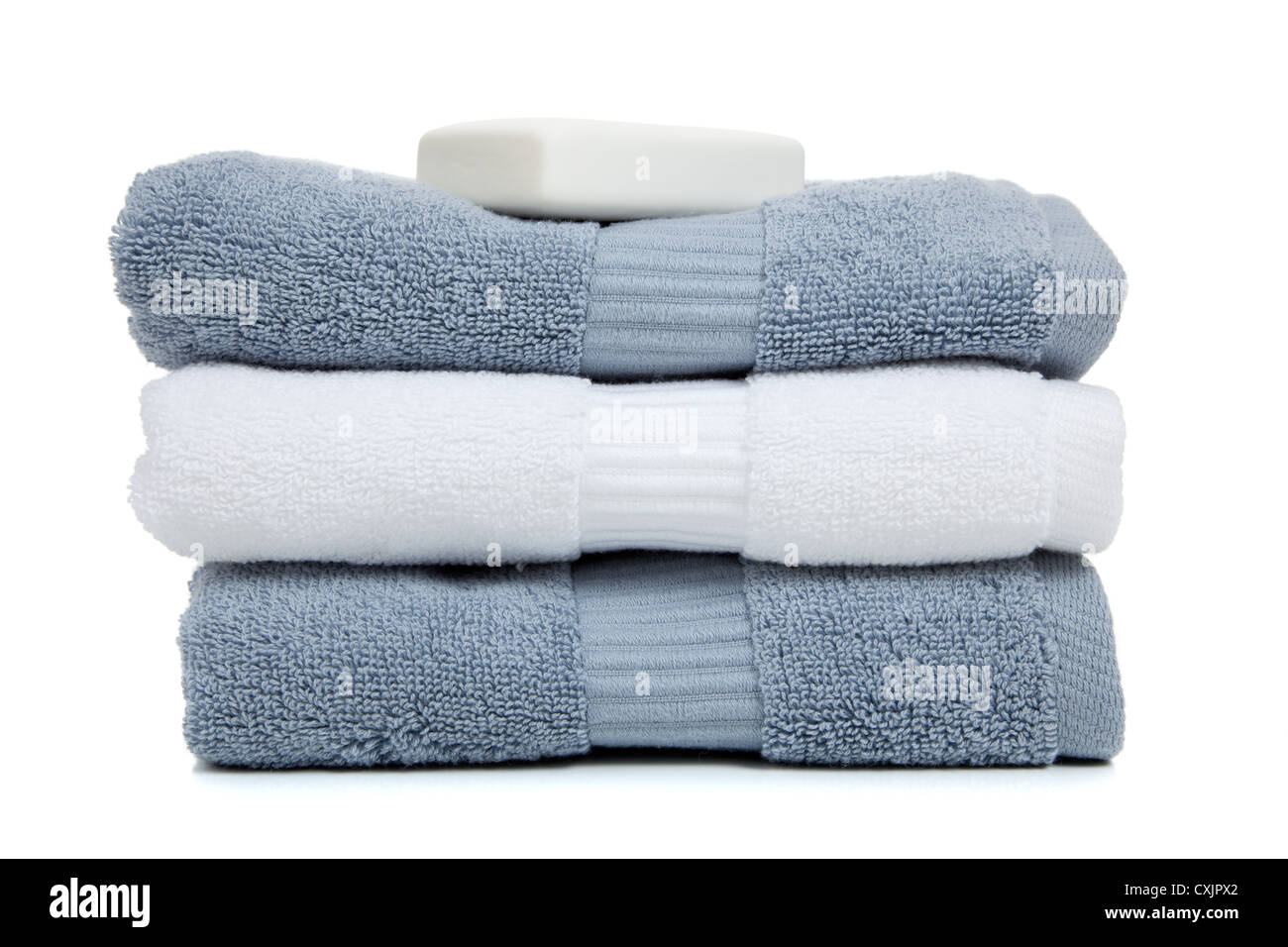 Stack of gray and white towels and a bar of soap on a white background Stock Photo