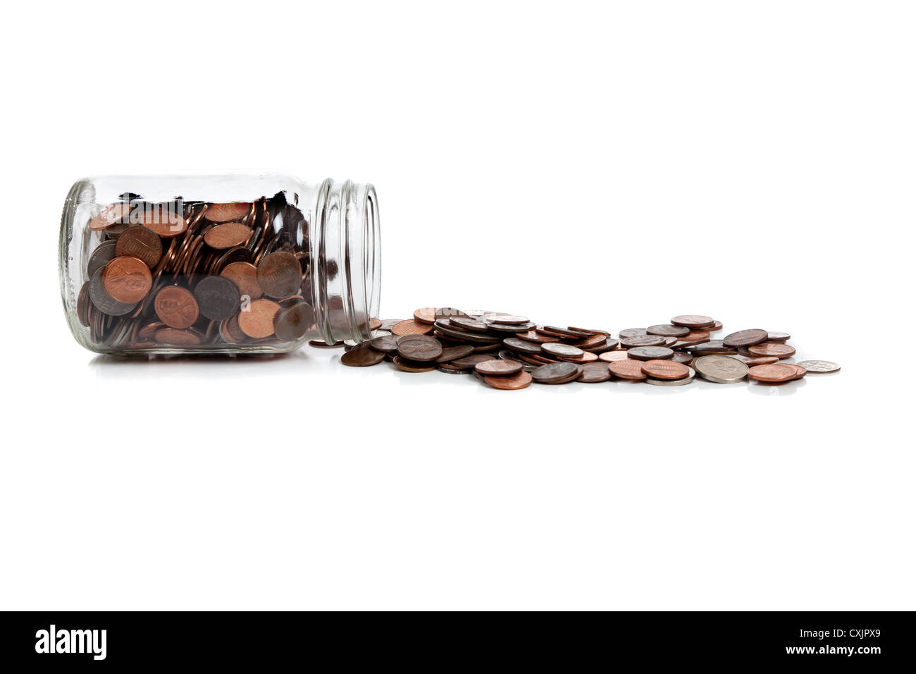 Glass jar spilled over with change coming out on a white background with copy space Stock Photo