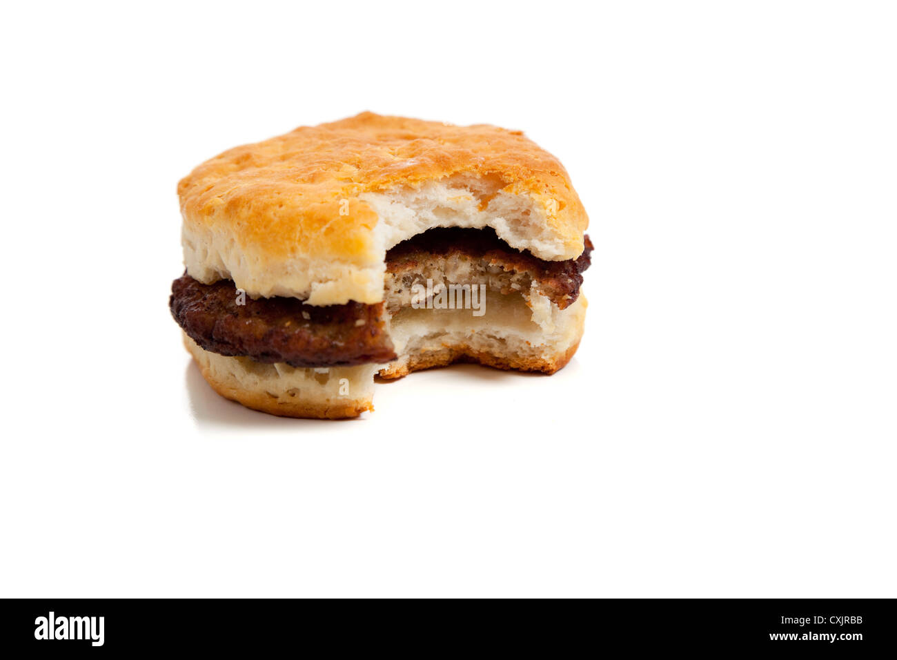 Sausage biscuit with a bit taken out of it on a white background Stock