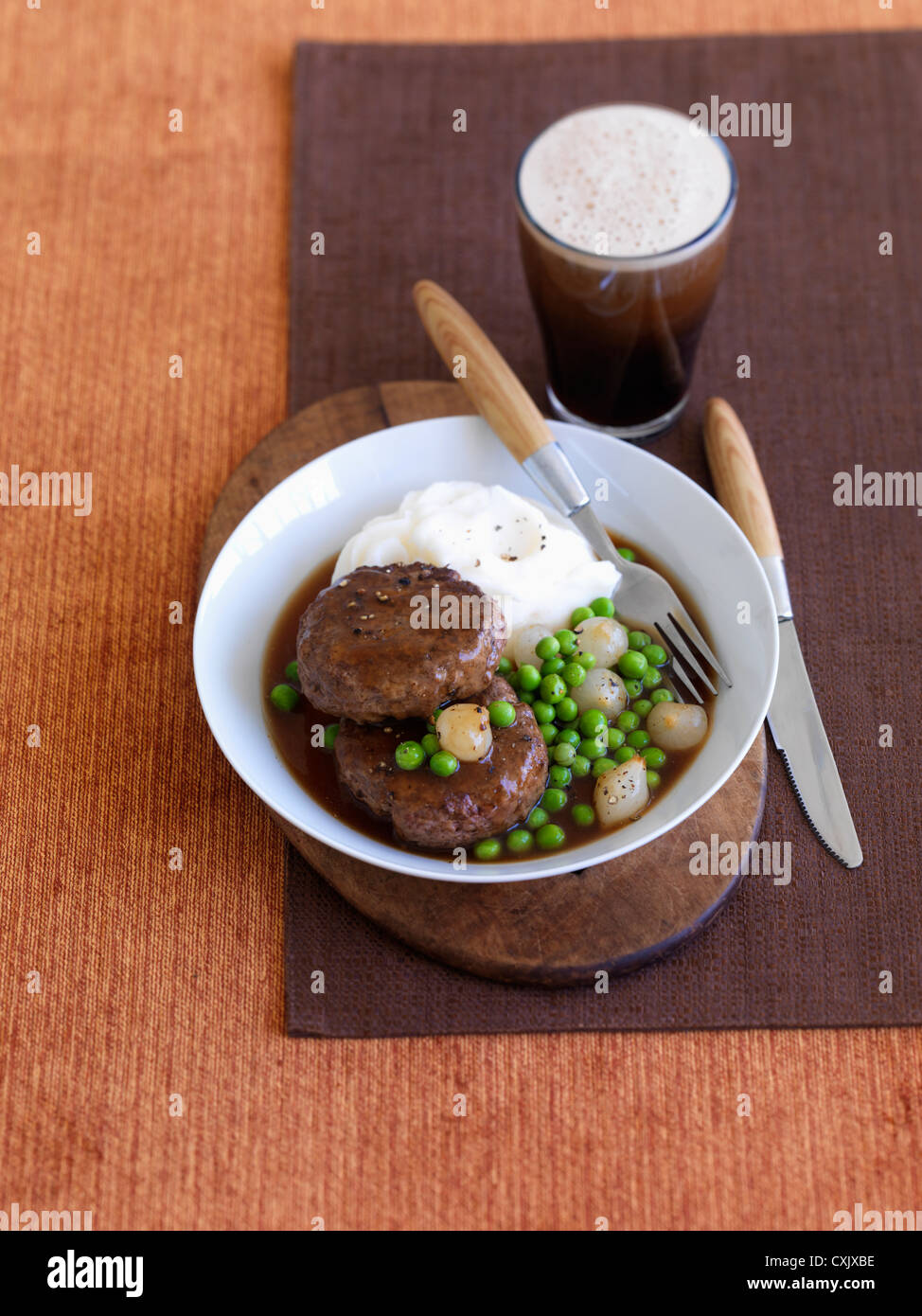 Beef Patty, Peas, Mashed Potatoes and Glass of Beer Stock Photo