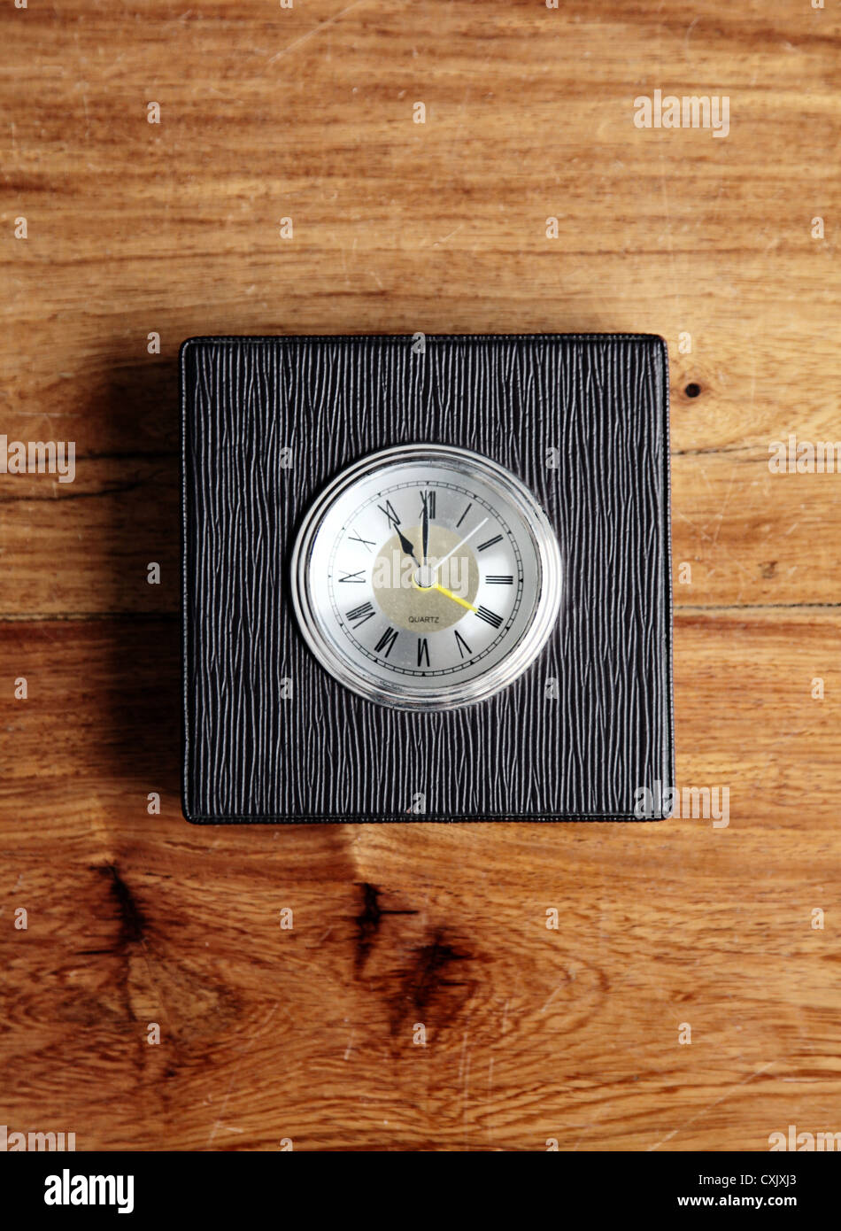 It's a photo of a clock or alarm clock that indicate nearly 11pm or 11am. It's a simple ans square little model. Stock Photo