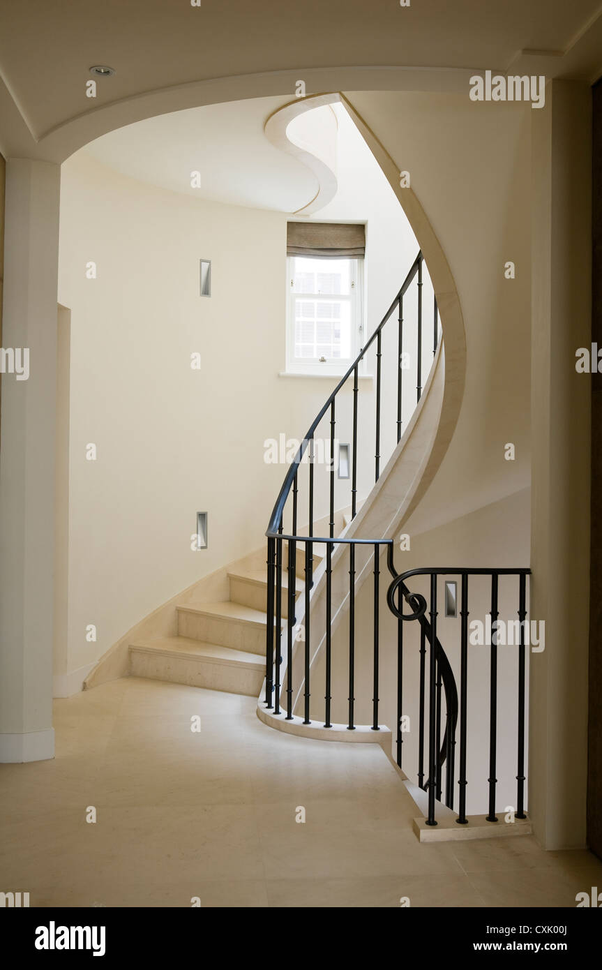 colour day interior neutral staircase spiral stairs banister wrought iron metal elegance landing window architecture flooring Stock Photo