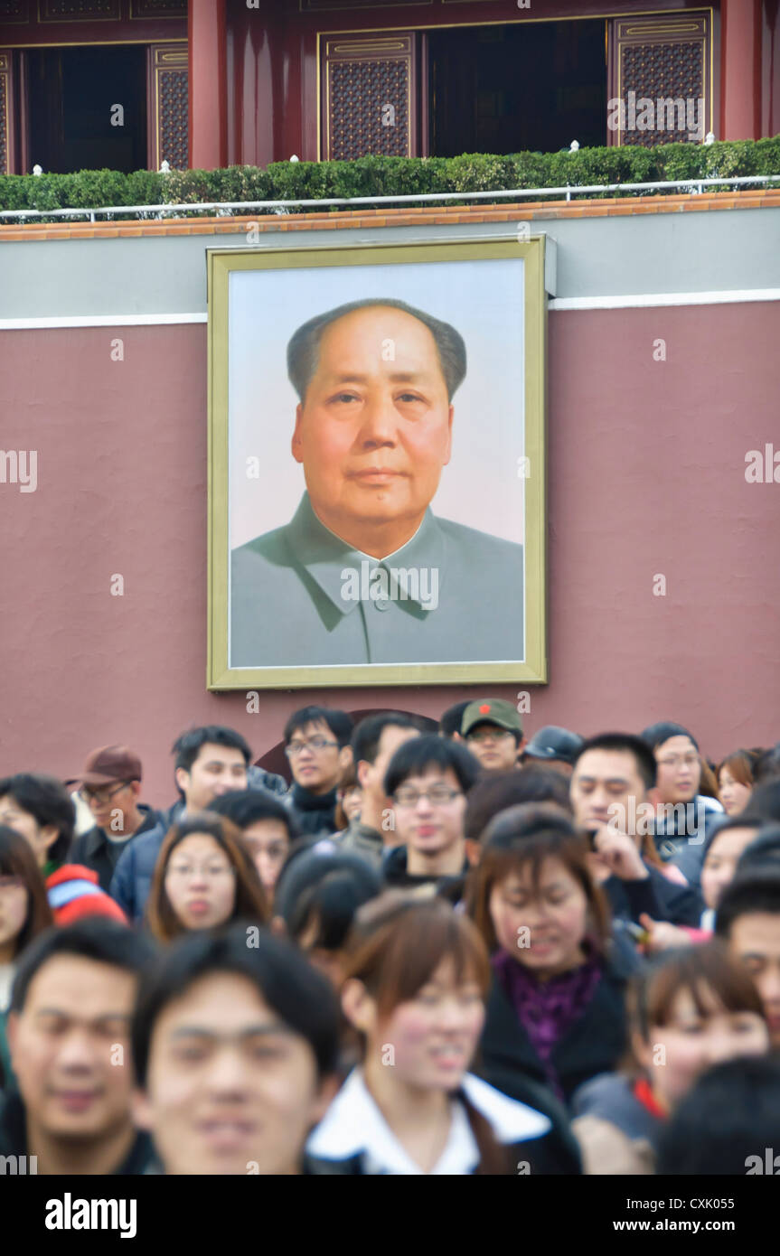 Crowds of visitors leaving the Forbidden City under the watchful gaze of Chairman Mao Stock Photo
