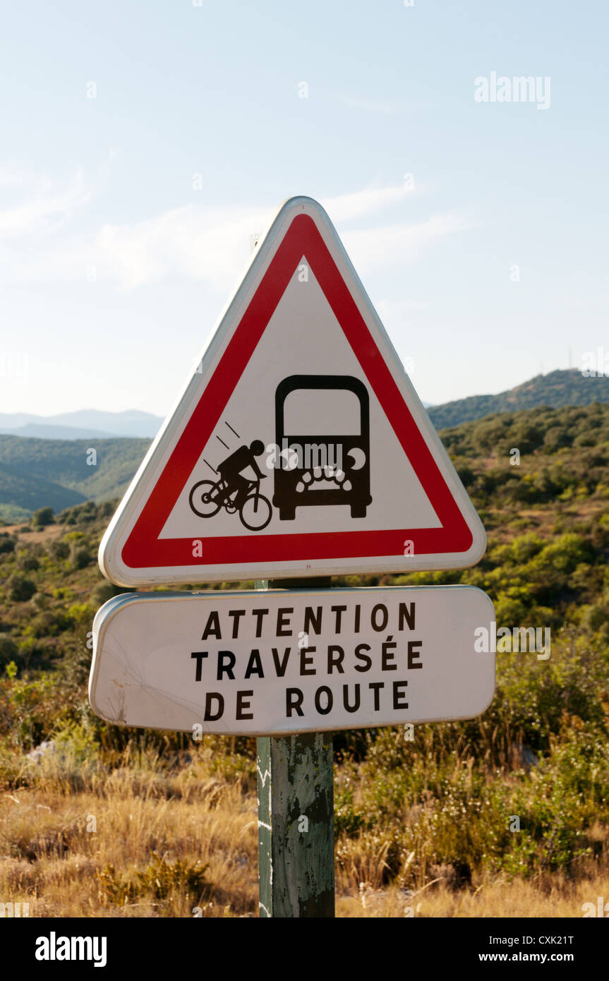 A sign warns off-road cyclists that they are about to cross a road. Stock Photo