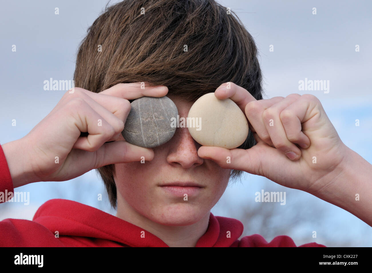 Teenage Boy holding Stones over Eyes, Sete, France Stock Photo Alamy