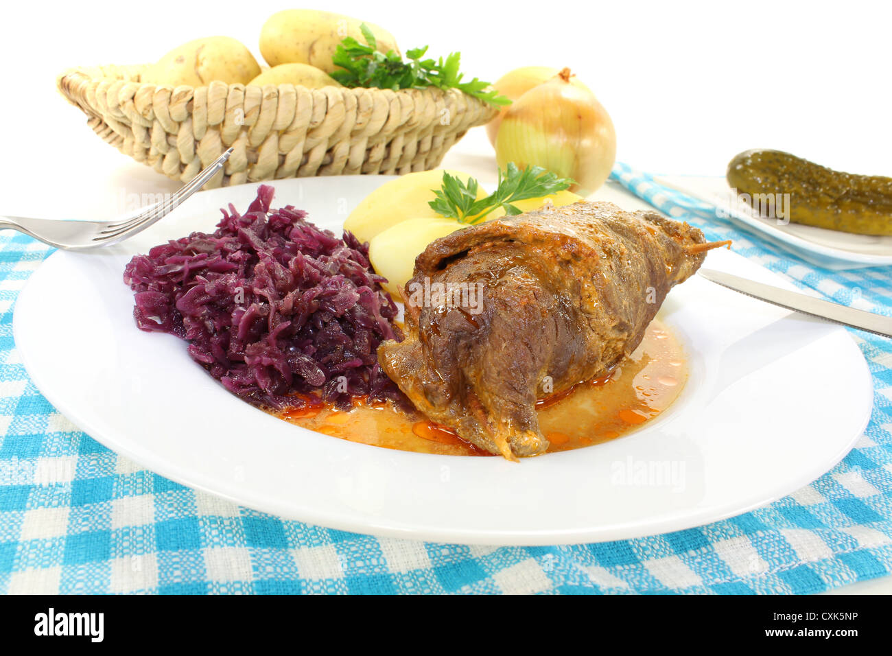 fresh roasted beef roulade with potatoes and red cabbage on a bright